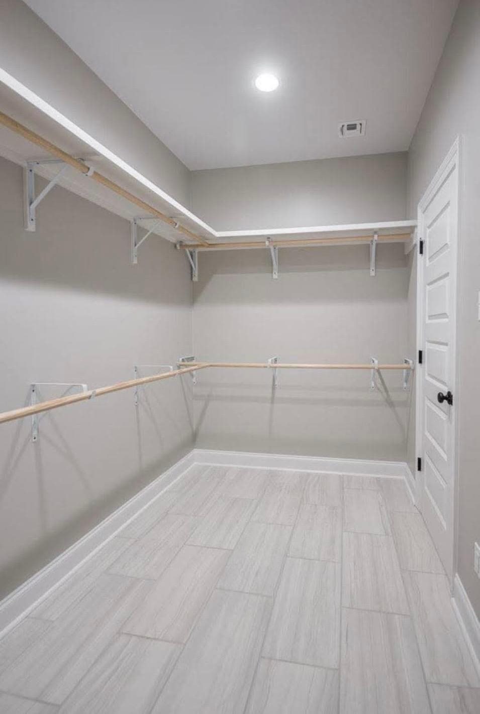 Walk-in closet with wood rods and white shelving